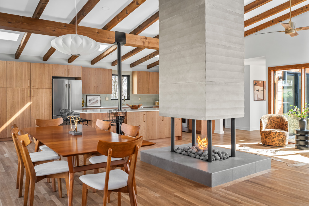 Open kitchen and dining room organized around the central fireplace