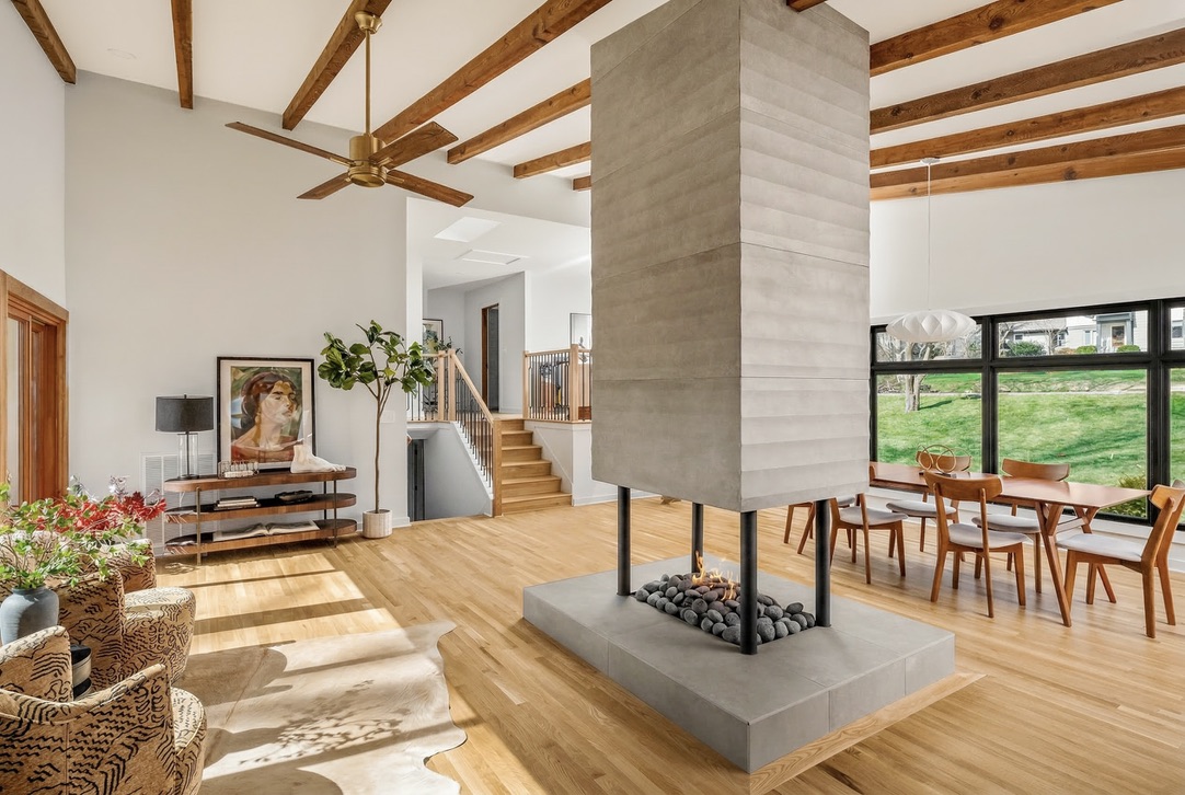 Central suspended fireplace connecting living and dining spaces