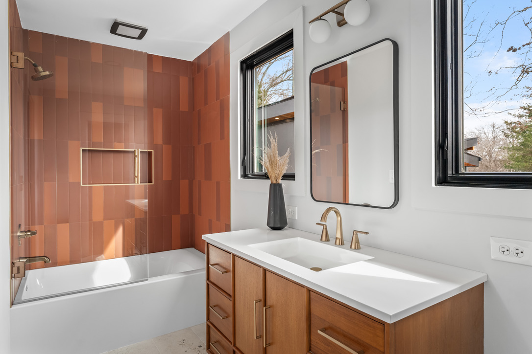 Guest bath with terracotta tile and warm wood cabinetry