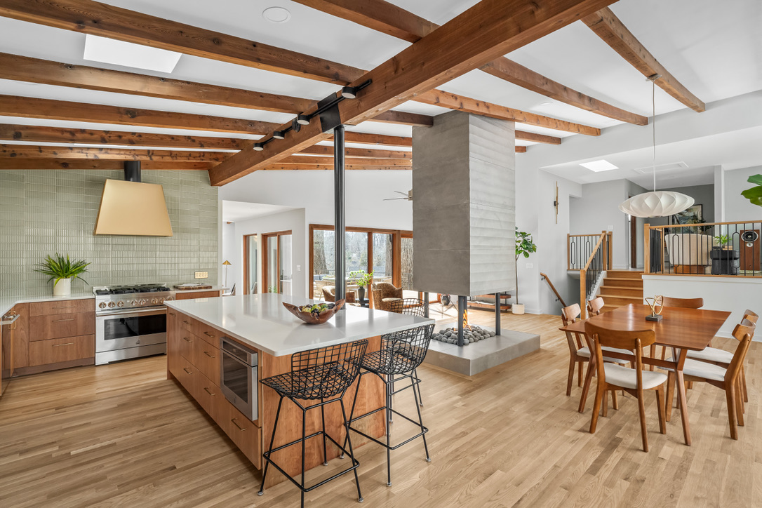Open kitchen and dining room centered around a sculptural fireplace